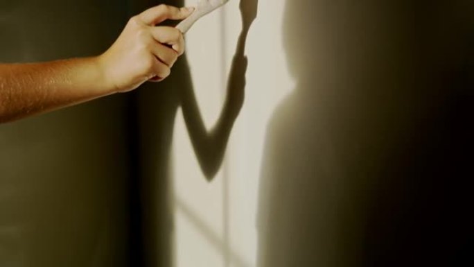 女人用白色油漆画墙，慢动作