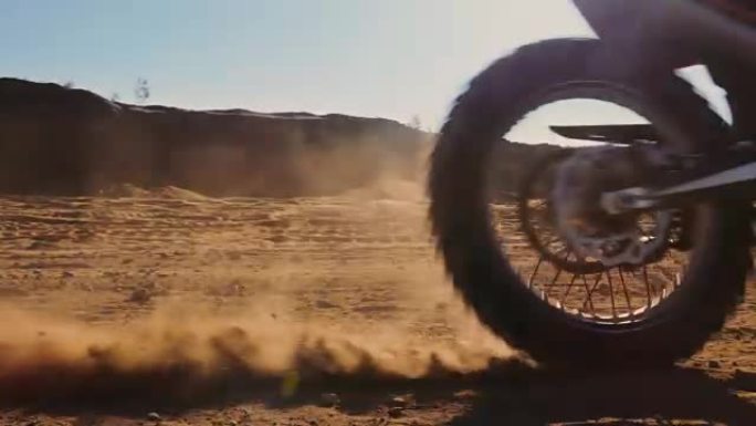 FMX越野自行车的车轮在沙地上行驶的低角度镜头。