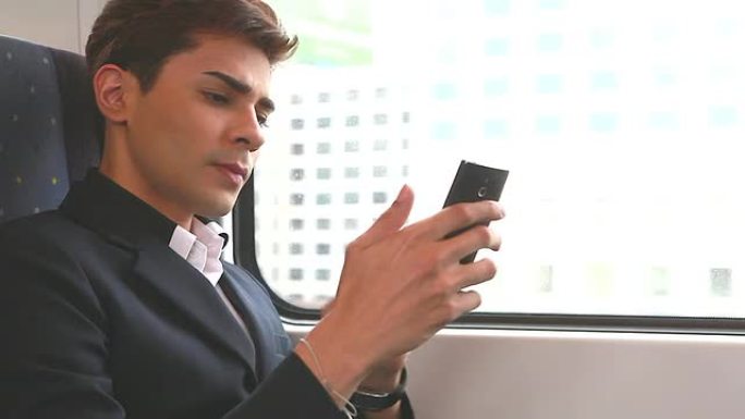 高清：商人在火车上用手机打字。