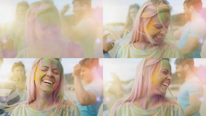 一个美丽的金发女孩的特写肖像和她的朋友们一起跳舞庆祝胡里节。她的脸上和衣服上布满了五颜六色的粉末。