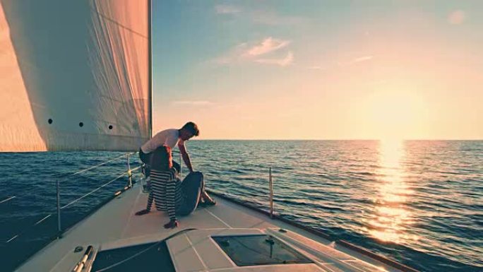 WS夫妇在日落时在帆船甲板上放松