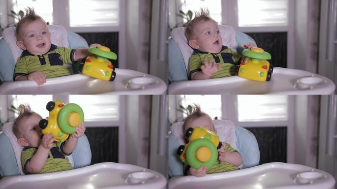 男婴玩玩具，坐在婴儿椅上。一岁的婴儿