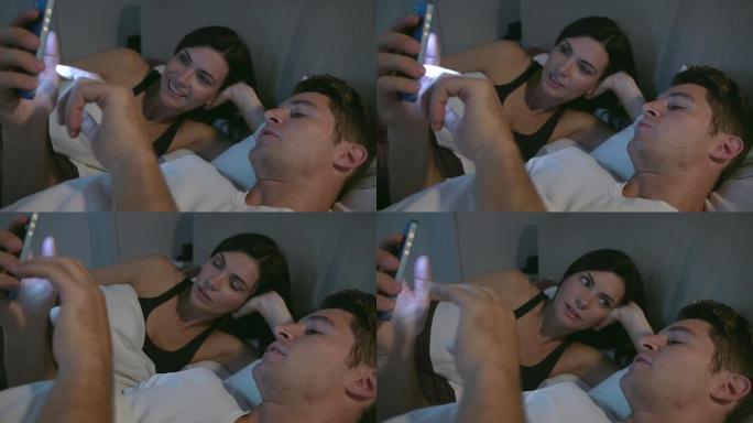 夫妻俩躺在床上一起看手机