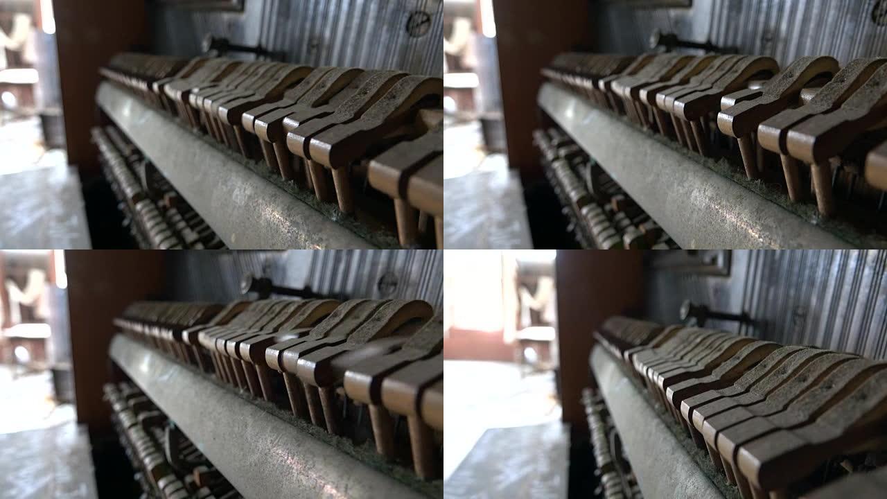 特写: 在旧的尘土飞扬的钢琴锤击中，产生旋律的琴弦
