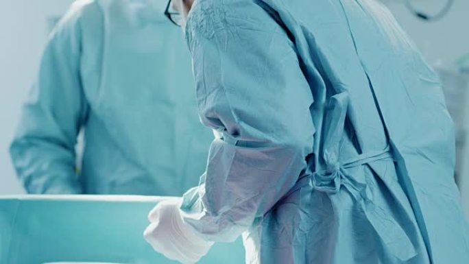 手术助手的特写镜头在手术期间将器械交给外科医生。手术正在进行中。进行手术的专业医生。