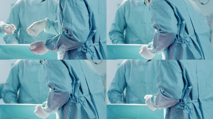 手术助手的特写镜头在手术期间将器械交给外科医生。手术正在进行中。进行手术的专业医生。