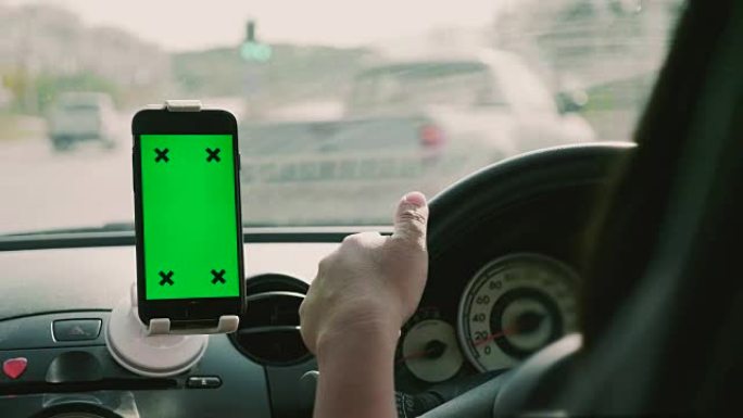 女人在带有GPS，绿屏的汽车中使用智能手机