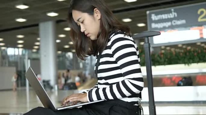 忙碌: 亚洲妇女在出发航站楼机场使用笔记本电脑