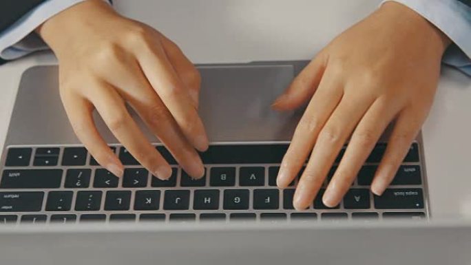 女人手在笔记本电脑上打字