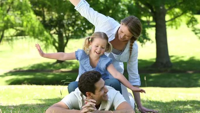 快乐的父母和他们的小女孩在公园里