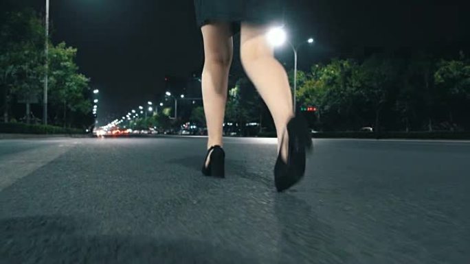 穿着高跟鞋的女人晚上走在街上