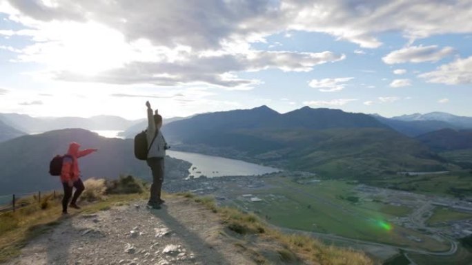 两人在日落时间登上山顶前徒步旅行