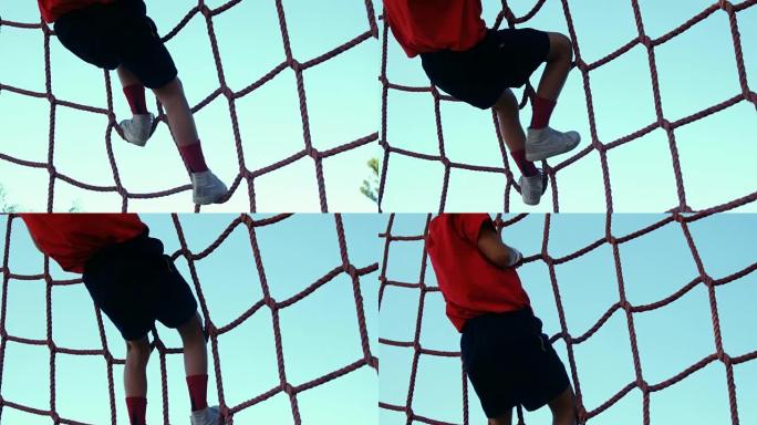 在障碍训练中爬网的男孩