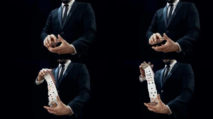 魔术师双手表演纸牌戏法的特写镜头。在空中投掷和捕捉卡片。背景是黑色的。慢动作。