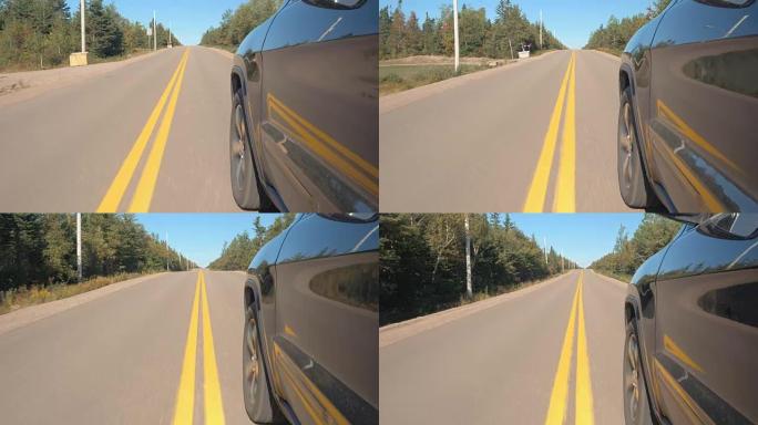 特写: 车辆沿着空旷的道路行驶，穿过广阔的加拿大荒野