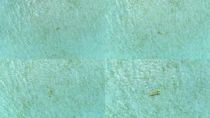 4k天线: 飞向躺在阳光明媚的波拉波拉岛美丽的海洋礁中间的绿色轻浮空气床床垫上的女人