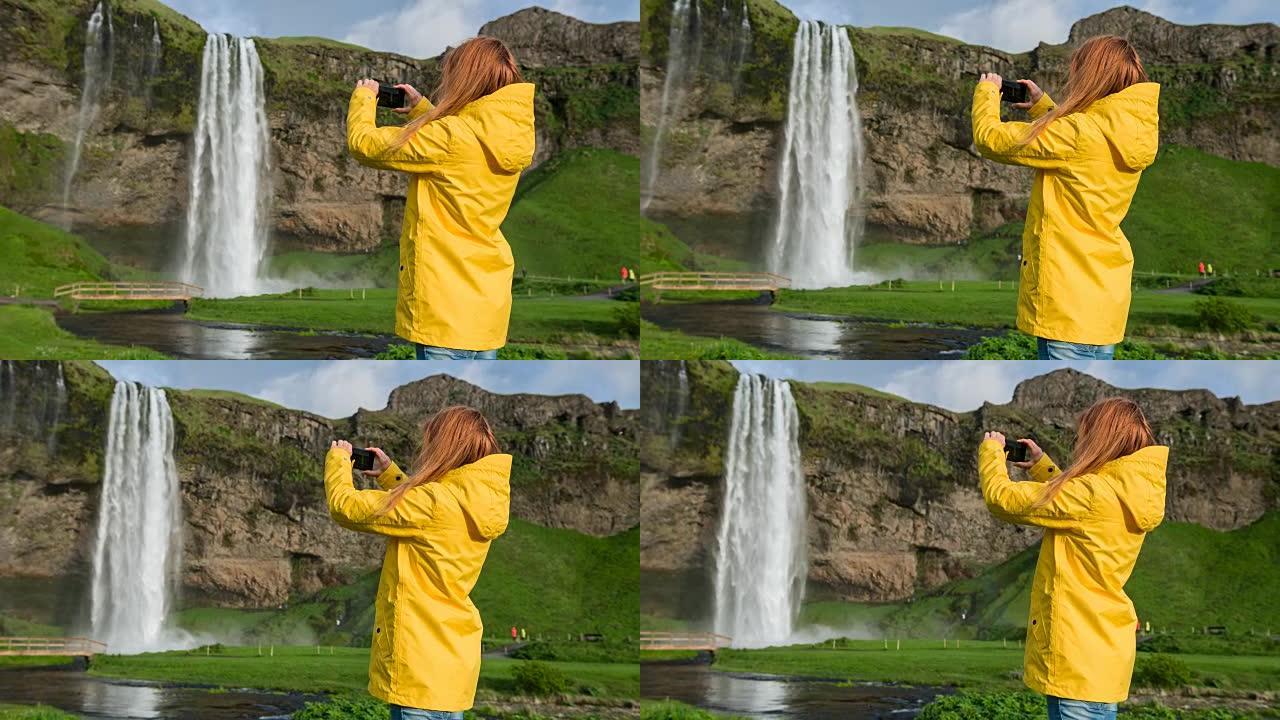 冰岛游客为Seljalandsfoss瀑布拍照