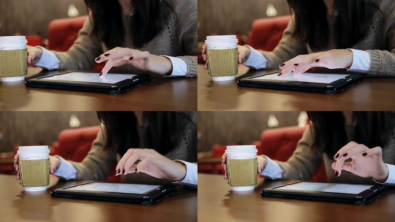 在咖啡馆使用平板电脑触摸屏的女人手