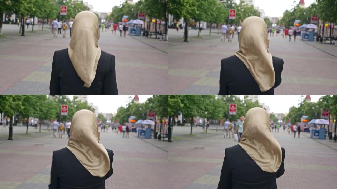 中东妇女在城市街道上接听电话