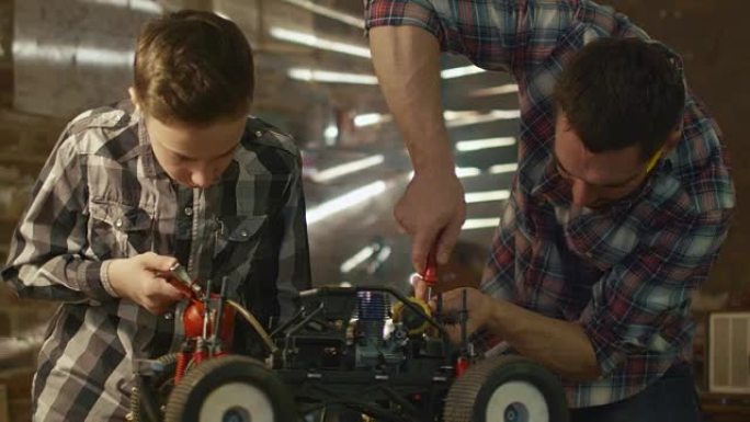 父子俩正在家里的车库里做无线电控制玩具车。