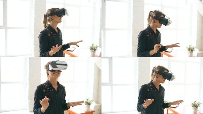 VR耳机中的女人在室内抬头并试图触摸虚拟现实中的物体