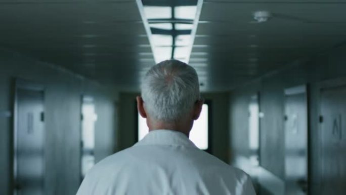 在专业男医生穿过医院走廊的镜头之后。肖像镜头。