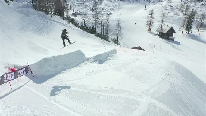 空中: 专业滑雪者在雪地公园跳大跳