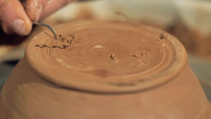 陶工在碗底侧做装饰。