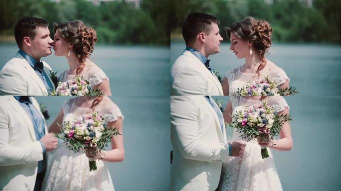 婚礼当天。美丽的夫妇享受他们的幸福站在码头上，接吻。婚纱，花束