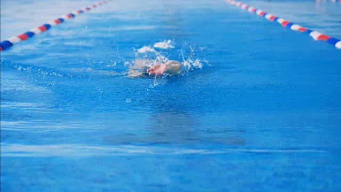 一个人在游泳池里游泳，特写。