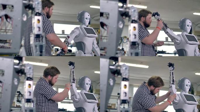 工程师抬起机器人的手臂，在其插槽中添加螺母。4K。