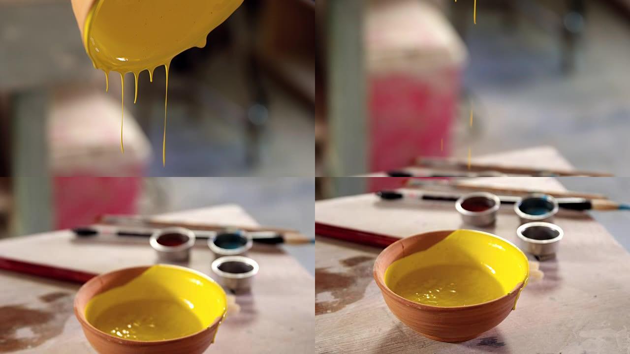 陶工在陶器车间将水彩倒在碗里
