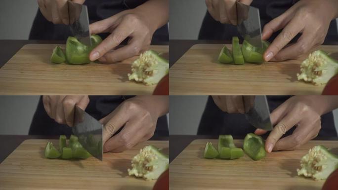 慢动作-女人在厨房的切菜板上制作健康食品和切碎甜椒的特写镜头。