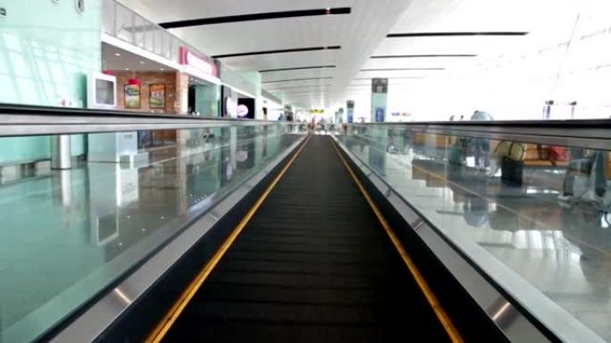 自动扶梯正在移动，可以看到商店和机场的人。
