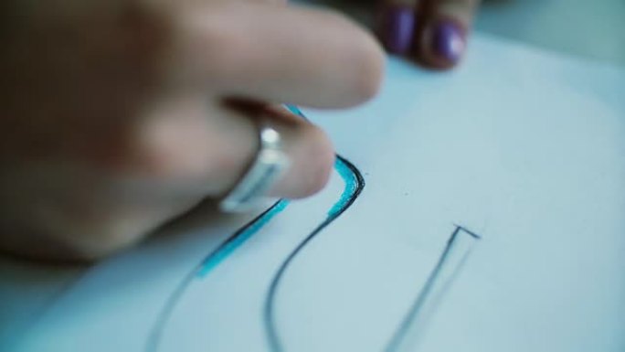 女人用蓝色铅笔手工着色鞋子布局的特写视图。开发新系列的年轻设计师。4K