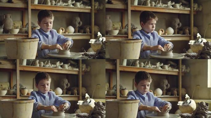 可爱的好奇孩子正在专业车间的旋转投掷轮上制作陶罐。陶瓷花瓶，手工罐，陶工工具可见。