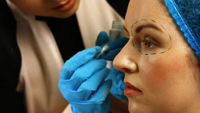 整形外科医生在女人的眼睛周围画