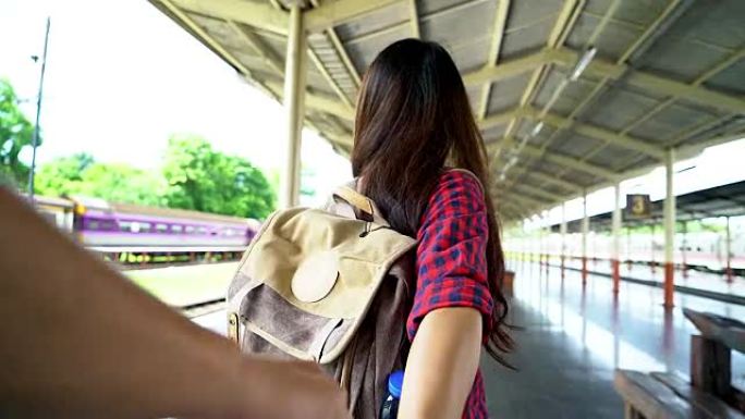 4K: 年轻女子牵着男人的手。专注于手，在火车站旅行概念