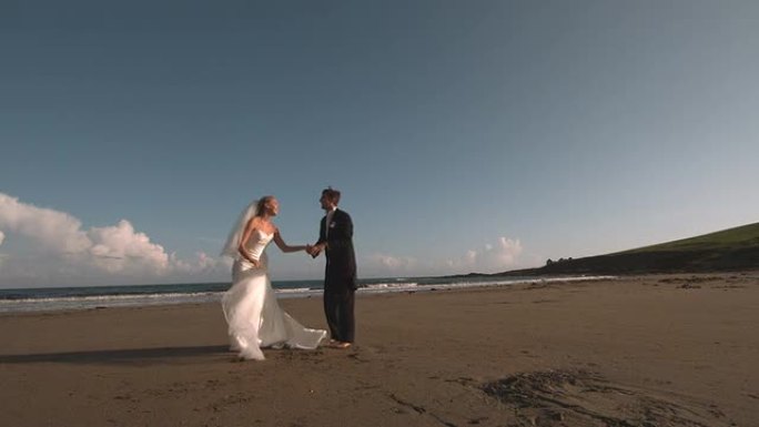 迷人的新婚夫妇在海滩上奔跑