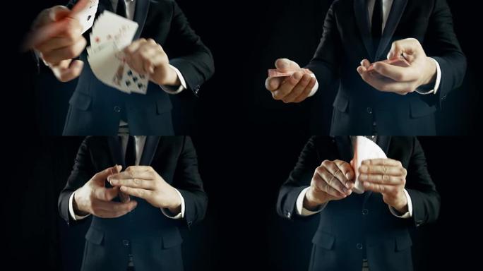 魔术师的手表演纸牌技巧的特写镜头，使纸牌扇出。魔术师穿着黑色西装，以黑色背景拍摄。