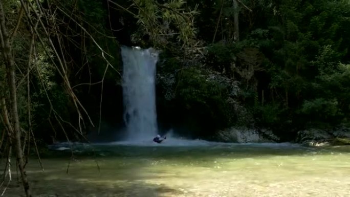 慢动作: 男子在汹涌的白水瀑布中划着皮划艇