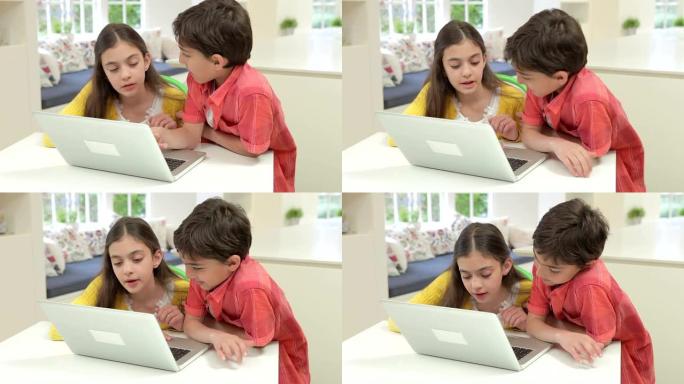 两名西班牙裔儿童在家中使用笔记本电脑