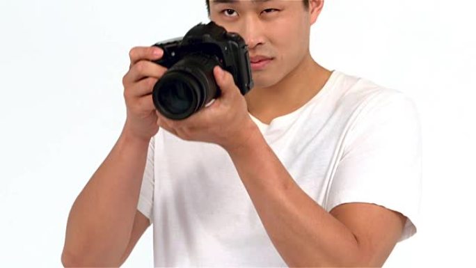 亚洲男子用专业相机拍照