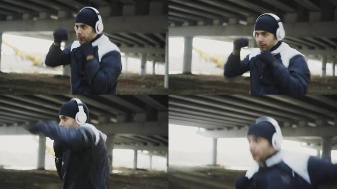 斯泰迪卡姆拍摄的戴着耳机的运动男拳击手冬季在城市户外进行拳击运动
