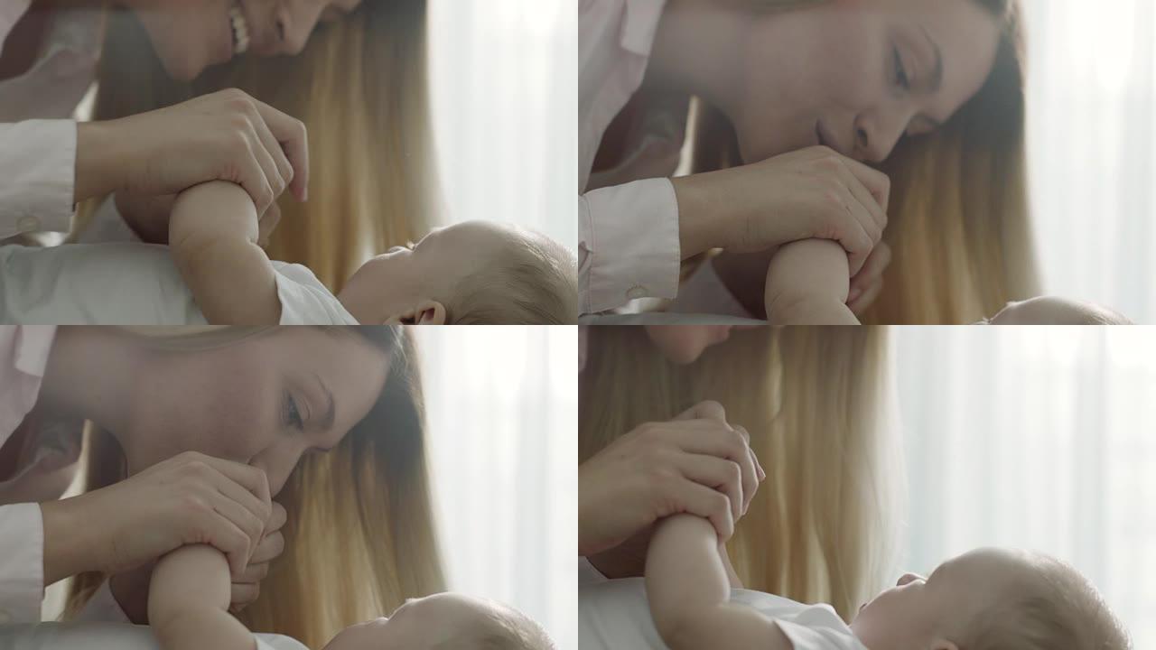 母亲亲吻婴儿的手