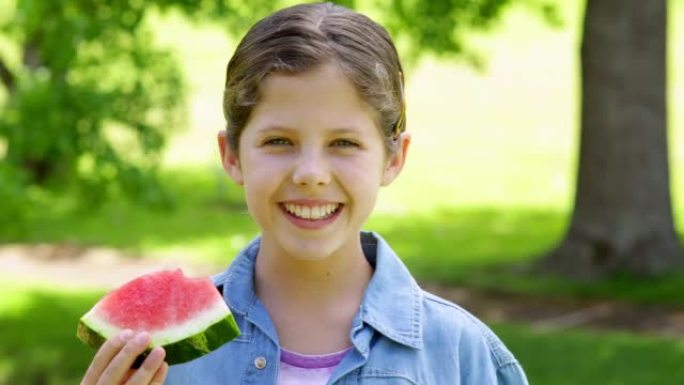 可爱的小女孩在公园吃西瓜