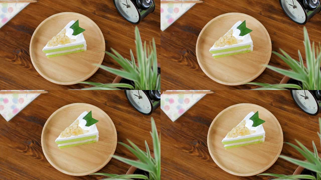 绿色蛋糕抹茶绿茶奶油蛋糕放在木桌上放松时间，多莉从右向左射击