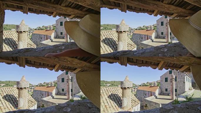 克罗地亚拉斯托沃，享受带瓷砖屋顶的石头建筑的女人
