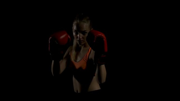年轻的女跆拳道太极拳作为训练格斗的运动。在黑暗中拳击。