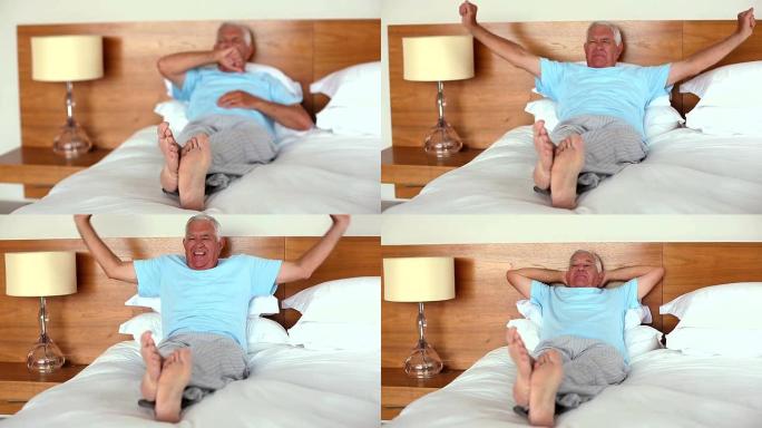 老人躺在床上打哈欠，伸懒腰